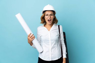 Miğferli genç Gürcü kadın izole edilmiş arka plan üzerinde şaşırtıcı bir yüz ifadesi olan planlar tutuyor.