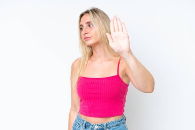 Beyaz arka planda izole edilmiş genç beyaz kadın dur hareketi yapıyor ve hayal kırıklığına uğruyor.