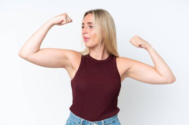 Beyaz arka planda izole genç beyaz kadın güçlü bir jest yapıyor.