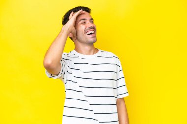 Genç yakışıklı adam, izole edilmiş sarı arka planda gülümsüyor.