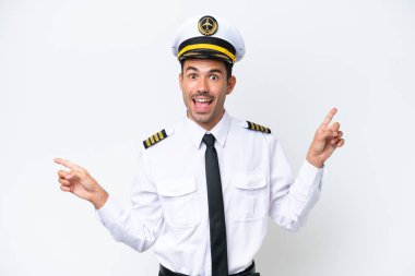 Airplane pilot over isolated white background pointing finger to the laterals and happy