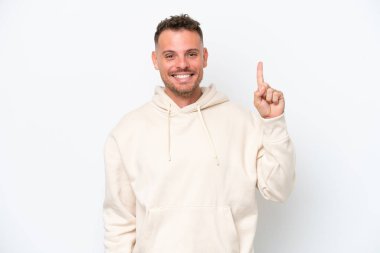 Beyaz arka planda izole edilmiş beyaz, yakışıklı genç bir adam harika bir fikre işaret ediyor.