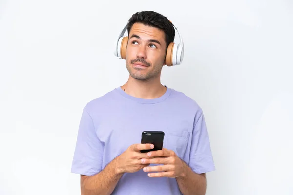 Jonge Knappe Man Geïsoleerde Witte Achtergrond Luisteren Muziek Met Een — Stockfoto