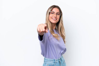 Genç Uruguaylı kadın beyaz arka planda izole edilmiş mutlu bir ifadeyle cepheyi işaret ediyor