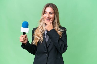 Genç, güzel Uruguaylı televizyon sunucusu izole edilmiş arka planda yan tarafa bakıyor ve gülümsüyor.