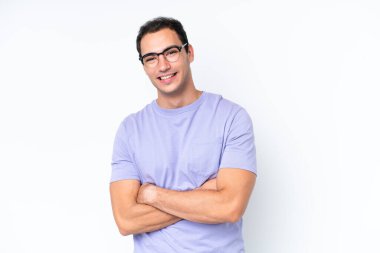 Beyaz arka planda izole edilmiş, kolları çapraz ve ileriye bakan genç beyaz bir adam.