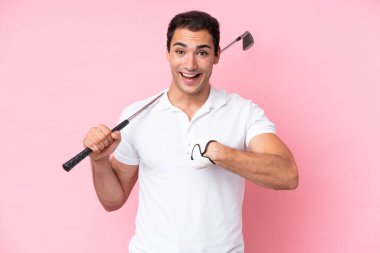 Young golfer player man isolated on pink background with surprise facial expression