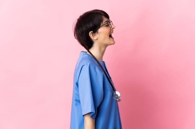 Cerrah pembe arka planda izole edildi. Yan pozisyonda gülüyor.