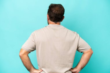 Middle age caucasian man isolated on blue background in back position