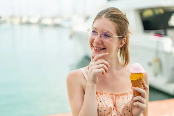 アイデアを考えて外でコルネットアイスクリームを保持するフランス人少女 — ストック写真