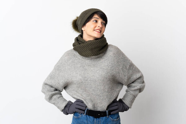 Young girl with winter hat posing with arms at hip and smiling