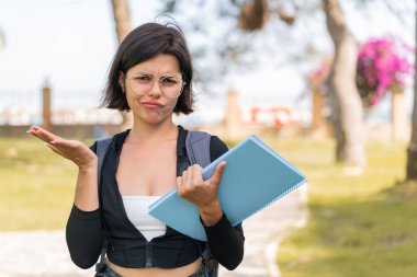 Genç Bulgar öğrenci kadın açık havada omuzlarını kaldırırken şüpheyle hareket ediyor