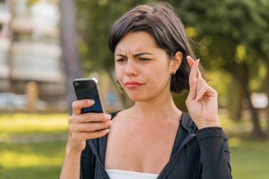 Açık havada genç ve güzel bir Bulgar kadın cep telefonu kullanıyor.