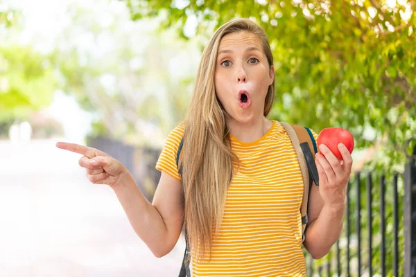 Junge Blonde Frau Mit Einem Apfel Freien Überrascht Und Zeigt — Stockfoto