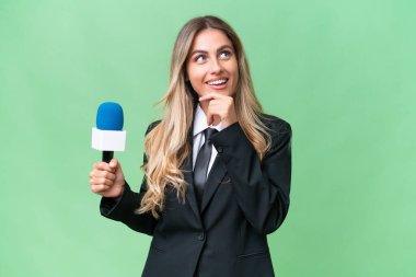Genç, güzel Uruguaylı televizyon sunucusu, izole edilmiş arka planda gülümserken yukarı bakıyor.