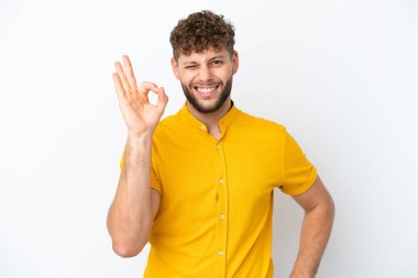 Beyaz arka planda izole edilmiş yakışıklı beyaz adam parmaklarıyla işaret veriyor.