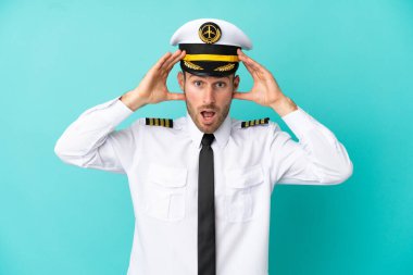 Airplane caucasian pilot isolated on blue background with surprise expression