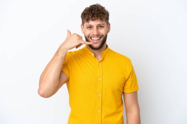 Beyaz arka planda izole edilmiş yakışıklı beyaz bir adam telefon jesti yapıyor. Bana geri dönüş işareti ver.