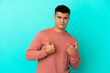 Young handsome man over isolated blue background pointing to oneself