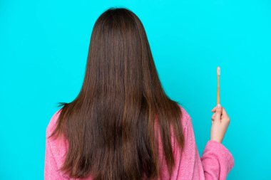 Genç Brezilyalı dişlerini fırçalayan kadın arka planda mavi arka planda izole edilmiş.