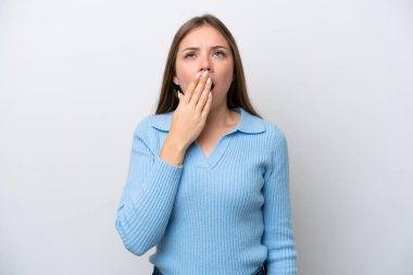 Genç Litvanyalı bir kadın beyaz arka planda izole edilmiş esniyor ve ağzını eliyle açık tutuyor.