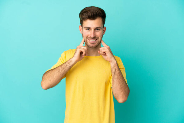 Young caucasian handsome man isolated on blue background smiling with a happy and pleasant expression