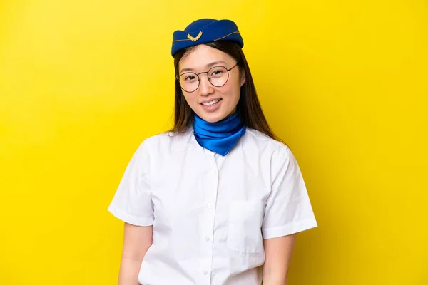 Airplane Chinese woman stewardess isolated on yellow background with glasses and happy