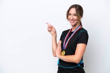 Young caucasian woman with medals isolated on white background pointing finger to the side