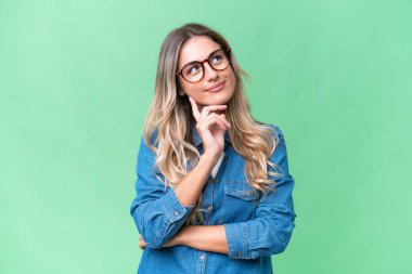 Genç Uruguaylı kadın izole edilmiş bir arka plan araştırırken bir fikir düşünüyor.