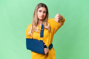 Kırık kollu genç Uruguaylı kadın ve izole edilmiş arka planda askısı var.