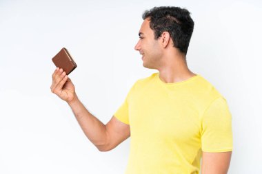 Young caucasian man holding a wallet isolated on white background with happy expression