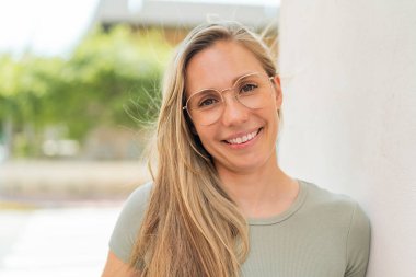 Açık havada genç sarışın bir kadın Neşeli gözlükleriyle