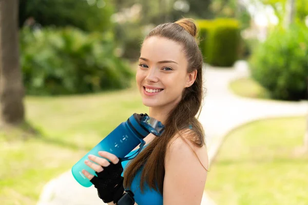 年轻漂亮的女孩在户外用一瓶水做运动 — 图库照片