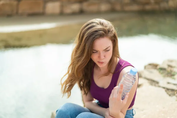 Jonge Roodharige Vrouw Met Een Fles Water Buitenlucht Met Droevige — Stockfoto