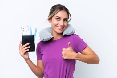 Şişirilebilir Seyahat Yastığı olan genç, güzel Uruguaylı kadın beyaz arka planda izole edilmiş bir şekilde baş parmak hareketi yapıyor.