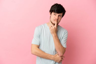 Pembe arka planda izole edilmiş genç bir Rus.