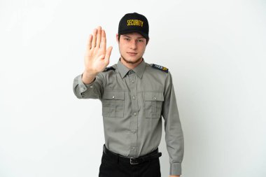 Beyaz arka planda izole edilmiş genç bir Rus güvenlik görevlisi dur işareti yapıyor.