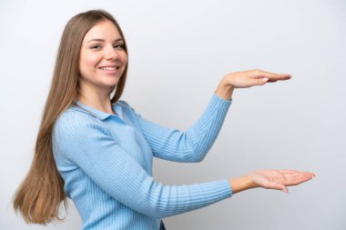 Genç Litvanyalı kadın beyaz arka planda izole edilmiş bir ilan vermek için kopyalama alanı tutuyor