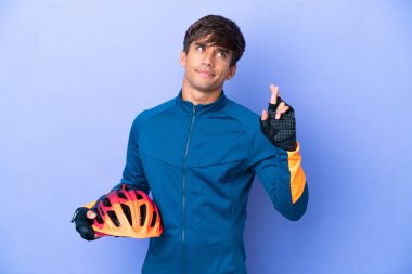 Mor arka planda izole edilmiş genç bir beyaz adam şans diliyor ve en iyisini diliyor.