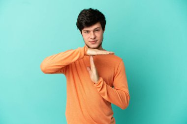 Genç Rus bir adam mavi arka planda izole edilmiş.