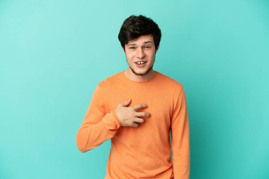 Mavi arka planda izole edilmiş genç bir Rus kendini işaret ediyor.