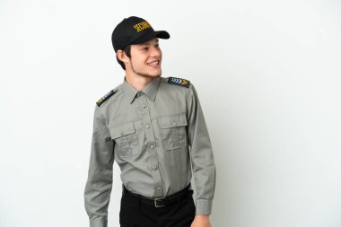Beyaz arka planda izole edilmiş genç bir Rus güvenlik görevlisi yana bakıyor ve gülümsüyor.