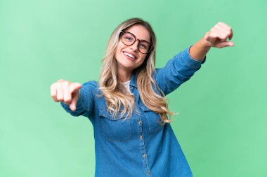 Genç Uruguaylı kadın izole edilmiş arka planda mutlu bir ifadeyle ön tarafı işaret ediyor