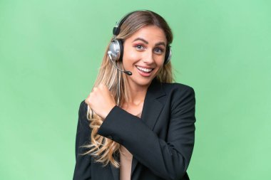 Tele pazarlamacı güzel Uruguaylı kadın tecrit edilmiş arka planda çalışan bir kulaklıkla zaferi kutluyor.