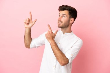 Pembe arka planda izole edilmiş genç beyaz adam işaret parmağıyla işaret etmek harika bir fikir.
