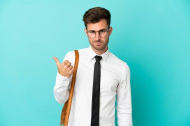 İzole edilmiş arka planda iş adamı bir ürünü sunmak için kenarı işaret ediyor.