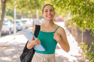 Yüzünde sürpriz bir ifade olan genç ve güzel bir bayan öğrenci.