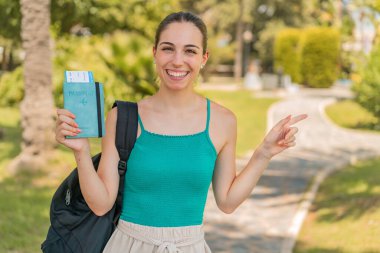 Pasaportu elinde tutan genç ve güzel bir kadın şaşırmış ve parmağıyla kenarı işaret ediyor.