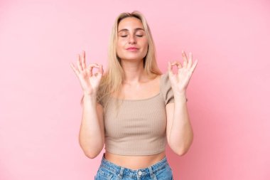 Zen pozunda pembe arka planda izole edilmiş beyaz bir kadın.