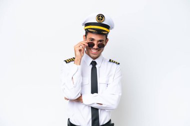 Airplane pilot over isolated white background with glasses and happy